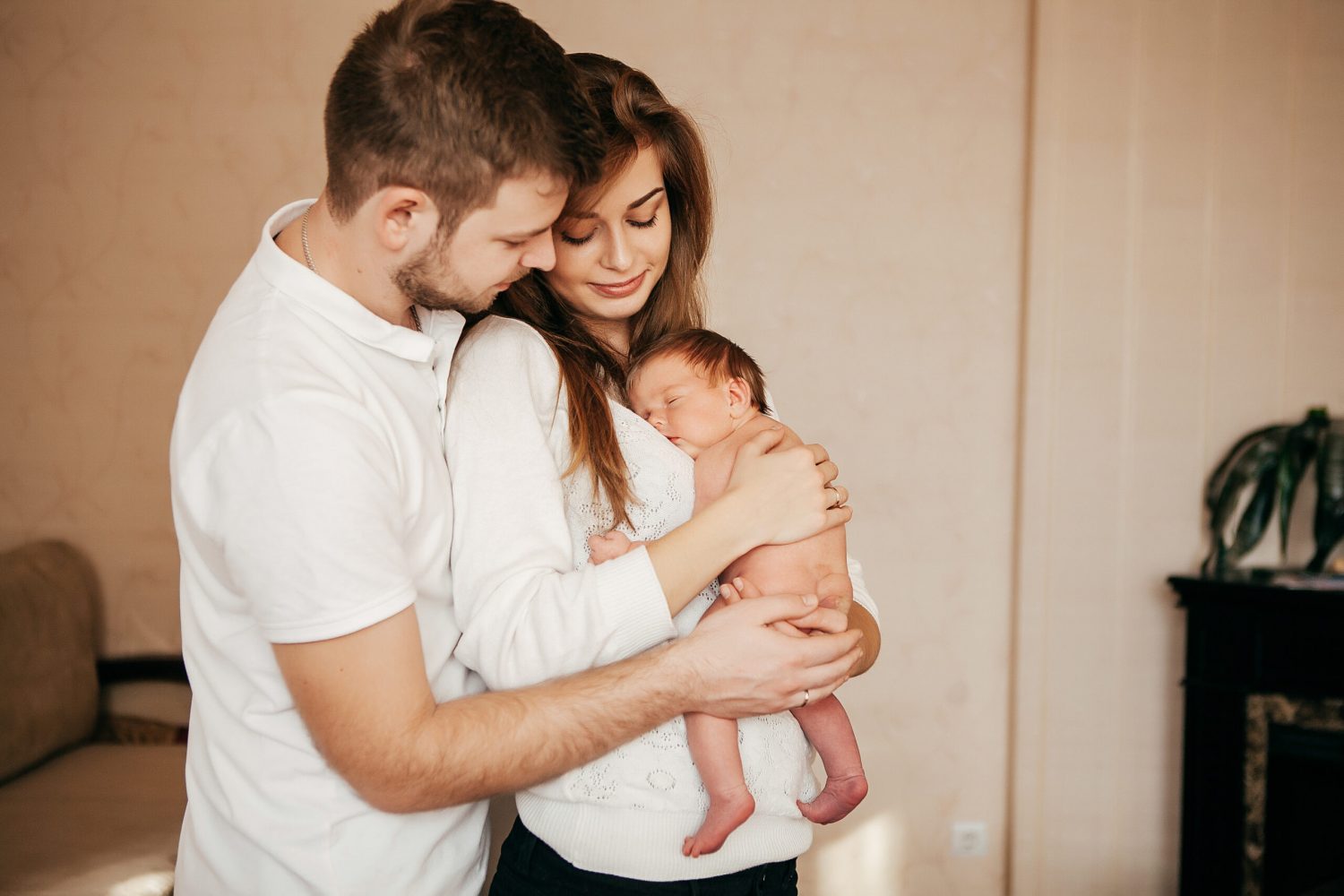 Newborn baby in the arms of young parents